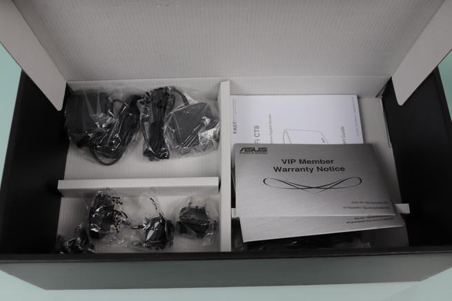Interior de la caja del ASUS ZenWiFi CT8 con accesorios y documentación
