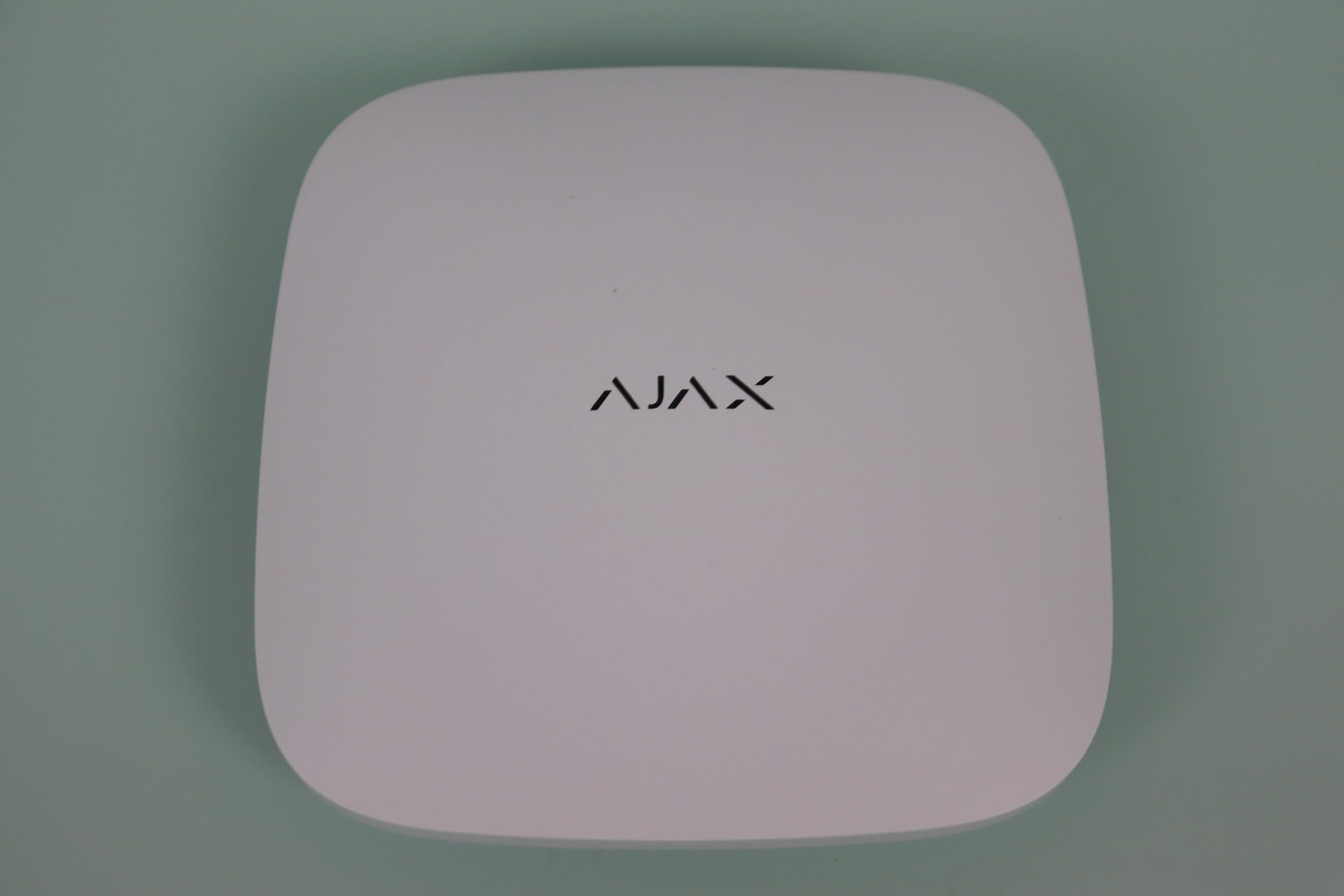 Panel frontal de la unidad central Ajax Hub 2 Plus en color blanco con el logotipo de la marca centrado.