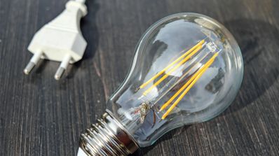Bombilla de filamento encendida, representando el concepto de potencia eléctrica y su impacto en la factura de la luz.