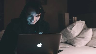 persona con el portatil en la cama