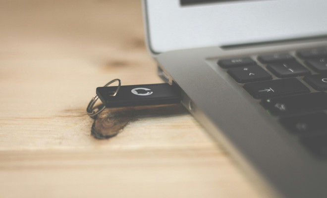 Adaptador USB-C multifunción conectado a un portátil, ilustrando cómo un dispositivo de apariencia normal puede ser un vector para un ataque de tipo BadUSB.