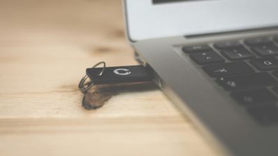 Adaptador USB-C multifunción conectado a un portátil, ilustrando cómo un dispositivo de apariencia normal puede ser un vector para un ataque de tipo BadUSB.