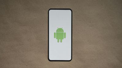 Smartphone con el logotipo de Android sobre una superficie de cartón marrón.
