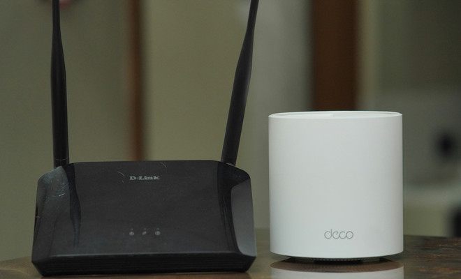 Router con luces LED encendidas junto con un nodo WiFi Mesh para ampliar cobertura