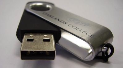 Usuario insertando un pendrive de seguridad con cifrado por hardware en un portátil para proteger documentos confidenciales