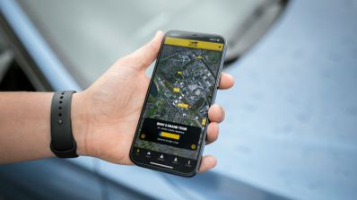 Persona sosteniendo un móvil con una app de navegación GPS mostrando una ruta urbana.