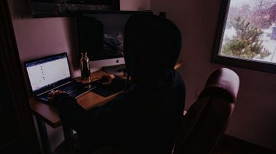 Un profesional gestiona la configuración de una red doméstica mediante un servicio NaaS en su ordenador portátil, con un entorno de oficina en casa de fondo.