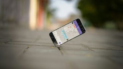 Primer plano de un iPhone mostrando una app de mapas con una ruta activa, simbolizando el uso de la localización por las aplicaciones.