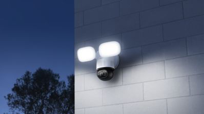 Cámara de seguridad Reolink TrackFlex Floodlight WiFi con sus dos focos LED de 3000 lúmenes iluminando una pared exterior por la noche