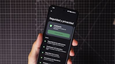 Una persona sostiene un móvil y en la pantalla aparece un análisis de virus