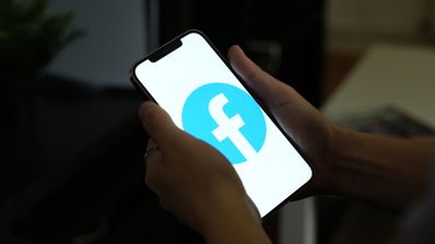 El logo de Facebook en la pantalla de un móvil que está sosteniendo una persona