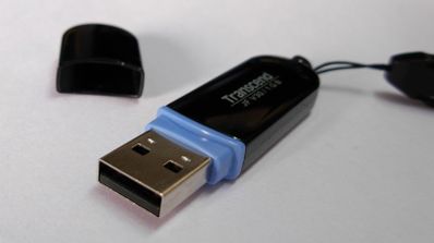 Una imagen de un pendrive de color negro, sobre una mesa