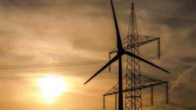 Imagen en la que aparece una torre de luz eléctrica y un molino de viento