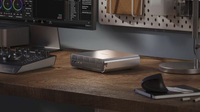 Servidor NAS all-flash QNAP TBS-h574TX de color oscuro sobre una mesa de madera, mostrando su diseño compacto y puertos frontales.
