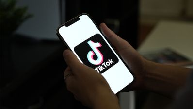 Imagen en la que aparece TikTok en la pantalla de un móvil
