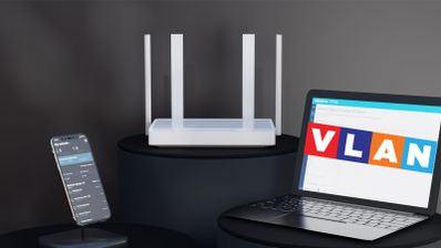 Router inalámbrico blanco con cuatro antenas junto a un portátil que muestra las siglas VLAN y un smartphone con una aplicación de gestión de red.