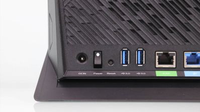 Detalle de las conexiones traseras de un router ASUS RT-AX86U con puertos USB 3.0, botón de encendido y entradas Ethernet.