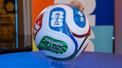 Balón oficial FIFA Trionda para el Mundial 2026 con diseño multicolor sobre soporte transparente.
