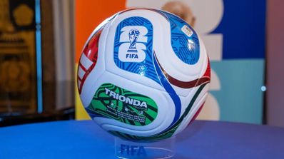 Balón oficial FIFA Trionda para el Mundial 2026 con diseño multicolor sobre soporte transparente.