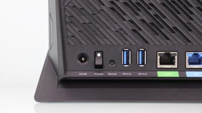 Detalle de los puertos traseros de un router ASUS RT-AX86U que incluye entrada de corriente, interruptor de encendido, dos puertos USB 3.0 y conexión Ethernet.