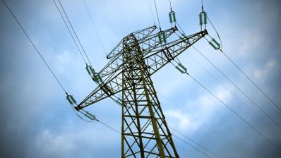 Torre de alta tensión con cables eléctricos bajo un cielo nublado.