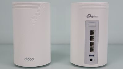 Dos nodos de un sistema Wi-Fi de malla TP-Link Deco de color blanco, mostrando la parte frontal con el logotipo y la parte trasera con cuatro puertos Ethernet y un puerto USB.