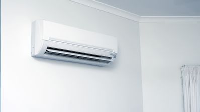 Unidad interior de aire acondicionado tipo split instalada en una pared blanca doméstica.