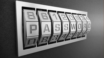 Cerradura metálica de combinación numérica y letras formando la palabra password sobre un fondo gris oscuro.