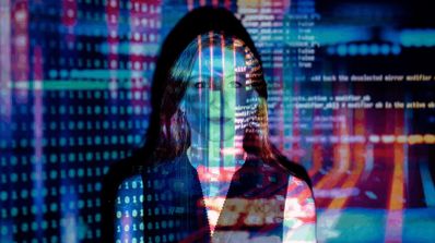 Silueta de mujer con capucha superpuesta sobre código de programación binario y líneas de datos en tonos azules y rojos.