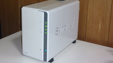 Servidor NAS Synology de color blanco con indicadores LED verdes encendidos sobre una mesa.