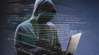 Persona con capucha frente a un ordenador portátil bajo capas superpuestas de código informático y una huella dactilar digital.