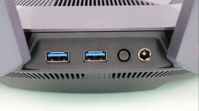 Primer plano de los puertos traseros de un router ASUS RT-AX89X que muestra dos conexiones USB 3.0, un botón de encendido y la toma de corriente.