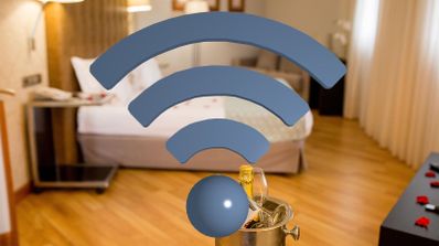Icono de señal Wi-Fi superpuesto sobre el interior de una habitación de hotel con cama, mesita de noche y suelo de madera.