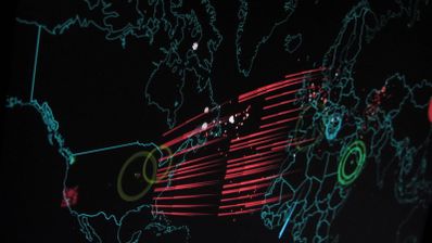 Mapa digital del mundo con líneas rojas que conectan América del Norte y Europa representando el flujo de un ataque cibernético.