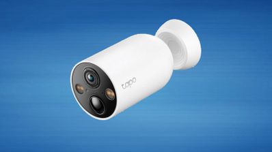 Cámara de seguridad TP-Link Tapo blanca con lente dual y focos integrados sobre fondo azul.