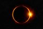 Eclipse solar total con el efecto de anillo de diamante sobre fondo estrellado.