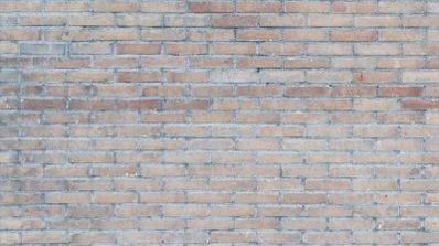 Primer plano de una pared de ladrillo visto en tonos tierra y grisáceos.
