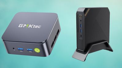 Dos mini ordenadores, uno de la marca GMKtec en formato horizontal y otro en posición vertical sobre un soporte.