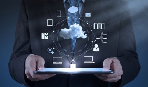 Persona con traje sosteniendo una tablet de la que emana un gráfico circular con iconos de servicios en la nube, dispositivos conectados y seguridad.