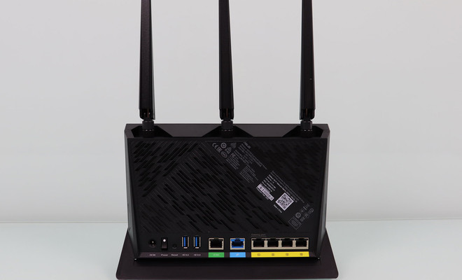 Panel posterior de un router ASUS RT-AX86U con tres antenas externas y puertos de conexión.