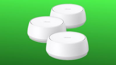 Tres nodos blancos de un sistema mesh de TP-Link Deco sobre fondo verde.