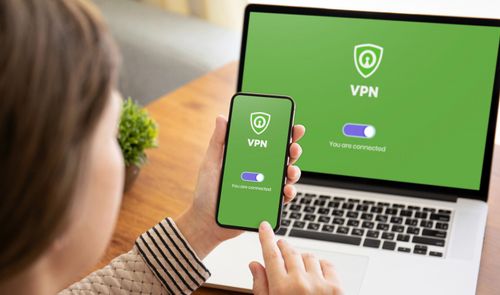 Persona utilizando una conexión VPN activa en su teléfono móvil y en un ordenador portátil de forma simultánea.