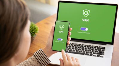 Persona utilizando una conexión VPN activa en su teléfono móvil y en un ordenador portátil de forma simultánea.