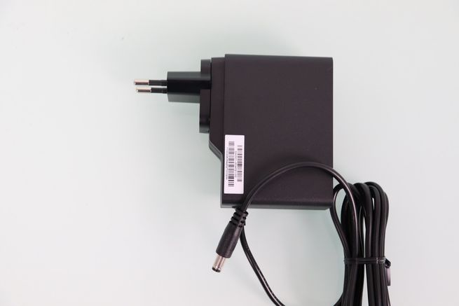 Perfil lateral del adaptador de corriente negro para el router ASUS GT-BN98 con el enchufe europeo montado.