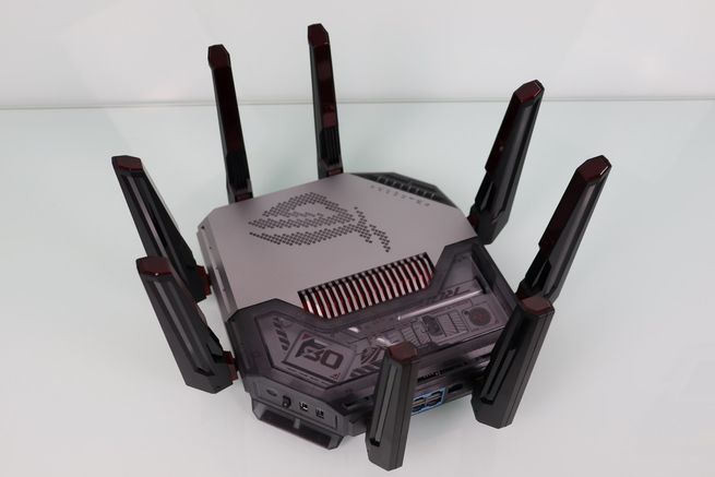 Primer plano en ángulo del router ASUS GT-BN98 mostrando el detalle del chasis metálico y las aberturas de refrigeración.