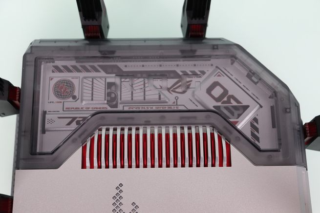 Detalle de la parte superior del router ASUS GT-BN98 con cubierta translúcida y rejillas de ventilación rojas.