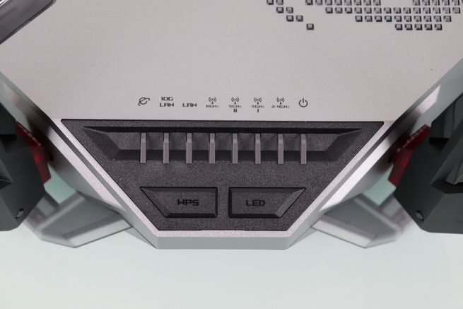 Panel frontal del router ASUS GT-BN98 mostrando indicadores luminosos de estado y botones físicos de WPS y LED.
