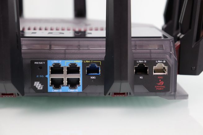 Panel posterior de un router ASUS GT-BN98 con puertos Ethernet LAN y WAN destacados en color azul.