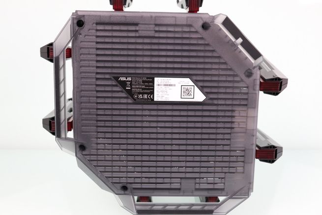 Parte inferior del router ASUS GT-BN98 con rejilla de ventilación y etiqueta de especificaciones técnicas.