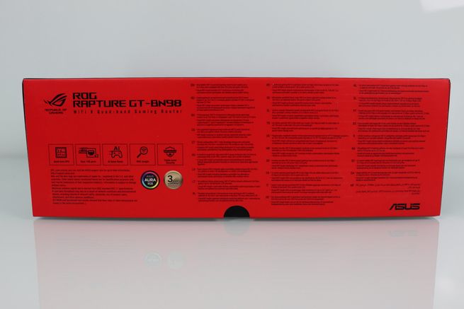 Lateral rojo de la caja del ASUS ROG Rapture GT-BN98 con iconos de funciones y textos descriptivos en varios idiomas.
